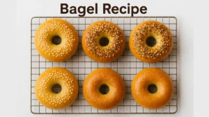 Best Bagel Recipe 14 Golden homemade bagels with sesame and everything seasoning displayed neatly on a cooling rack with ‘Bagel Recipe’ text above.