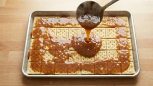 Valentine’s Day Crack Candy – The Sweet & Salty Treat Everyone Is Obsessed With 18 Pouring toffee over crackers