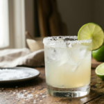 Classic margarita cocktail with lime and salted rim on rustic table.