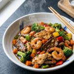 Triple delight Chinese food with chicken beef shrimp stir fry and vegetables in bow