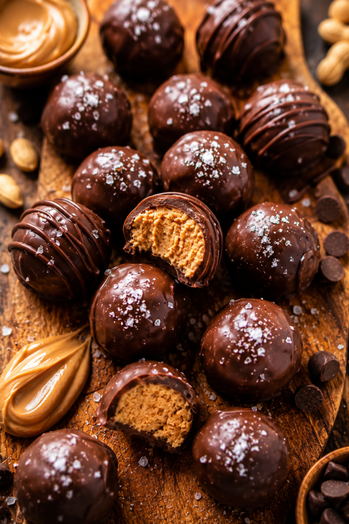 Peanut Butter Balls Recipe 13 Best peanut butter balls recipe with creamy peanut butter filling, rich chocolate coating, and flaky sea salt topping on a rustic wooden board.